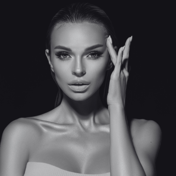 woman in black and white with hand on head